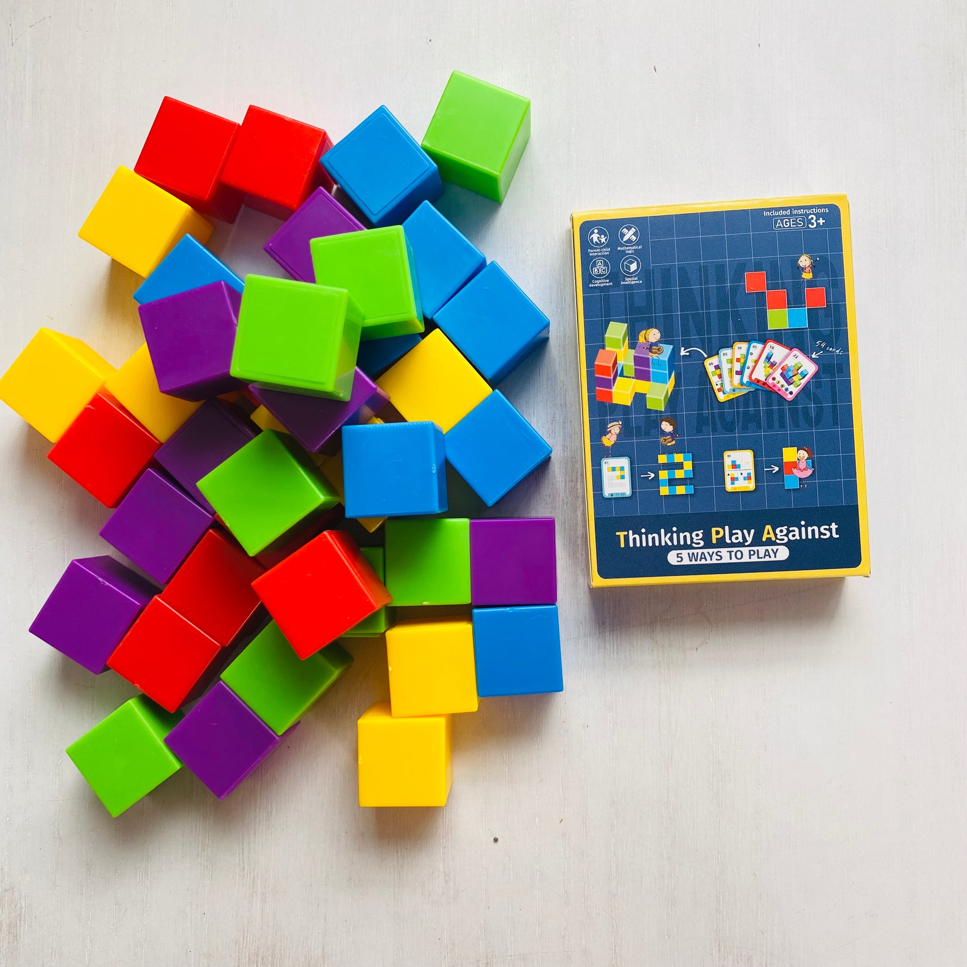 Logic puzzle with colored blocks and 27 double-sided challenge cards. Kids stack the blocks to match the cards.